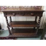 A Victorian carved oak three tier buffet with two drawers with mask handles, 104cm high x 115cm wide