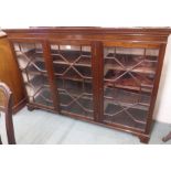 A three door glazed bookcase on bracket feet, 114cm high x 170cm wide x 44cm deep Condition