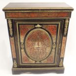 A BOULLE EBONISED WALNUT AND GILT METAL MOUNTED CABINET the door set with a raised oval panel