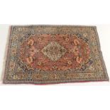 A PINK GROUND EASTERN RUG with a cream central medallion and floral design, 158cm x 104cm