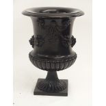 A COMPOSITE CLASSICAL STYLE URN cast with ribbon tied garlands of flowers above a lobed socle,