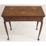 A DUTCH MARQUETRY OAK FOLD OVER CARD TABLE decorated with a basket of ribbon tied flowers,