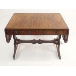 A REGENCY MAHOGANY AND OAK CROSSBANDED SOFA TABLE the twin flaps above four drawers and on reeded