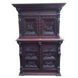 A FLEMISH OAK HALL CUPBOARD heavily carved with Medieval drinking scenes, with four doors and a