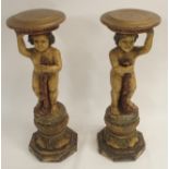 A PAIR OF CONTINENTAL POLYCHROME PINE PEDESTALS each carved with putti holding a robe and standing