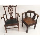 A VICTORIAN OAK CORNER ARMCHAIR the curved back rail set with conjoined dolphins and foliage and