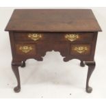 AN 18TH CENTURY OAK LOWBOY with a long drawer above a central scroll carve frieze and flanked by