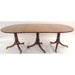 A MAHOGANY D-END DINING TABLE set on gun barrel columns with triple splayed legs, brass sabots and