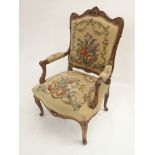 A LOUIS XVI STYLE WALNUT ARMCHAIR the carved frame with acanthus scrolls, the woolwork covers