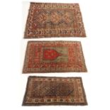 A RED GROUND CAUCASIAN RUG with geometric design, 172cm x 110cm, an indigo ground Eastern rug