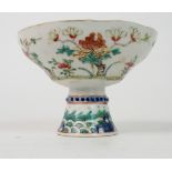A CHINESE STEMMED CUP painted with peonies above a band of waves, 10cm high and 14cm diameter