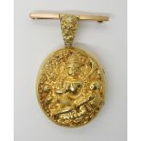 A YELLOW METAL INDIAN LOCKET DEPICTING THE HINDU GODDESS SARASWATI the Goddess of wisdom, riding