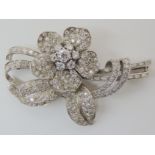 A DIAMOND FLOWER BROOCH set throughout in white metal and set with brilliant