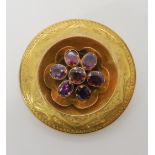 A VICTORIAN LOCKET BACK BROOCH made in yellow metal the body engraved with central garnet set motif,