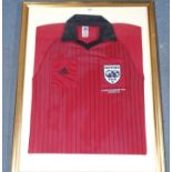 A RED AND BLACK 1998 FRANCE WORLD CUP REFEREE SHIRT with embroidered badge, framed and glazed, 88