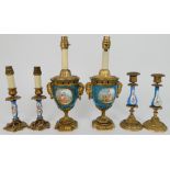A PAIR OF SEVRES STYLE URN LAMPS painted with courting couples and flowers, with ormolu rams mask
