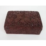 A CHINESE CINNABAR BOX AND COVER carved with kylin with precious objects and ribbons, above