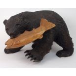 A BLACK FOREST STYLE CARVED BEAR WITH SALMON 46cm long x 33cm high Condition Report: Available