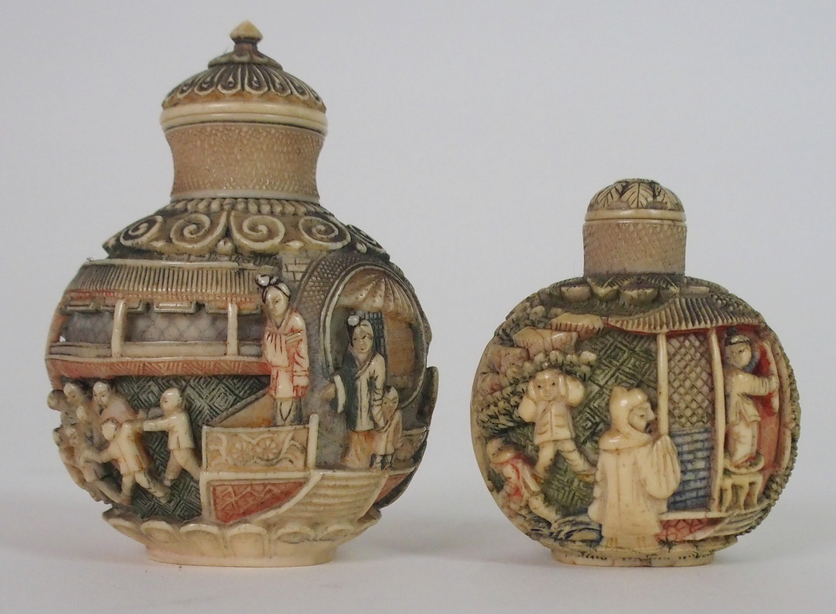 A CHINESE CARVED AND STAINED IVORY SNUFF BOTTLE decorated with figures on balconies and children