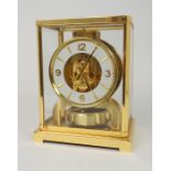 A JAEGER LE COULTRE ATMOS CLOCK in a gilt brass case, the cream chapter ring with baton and