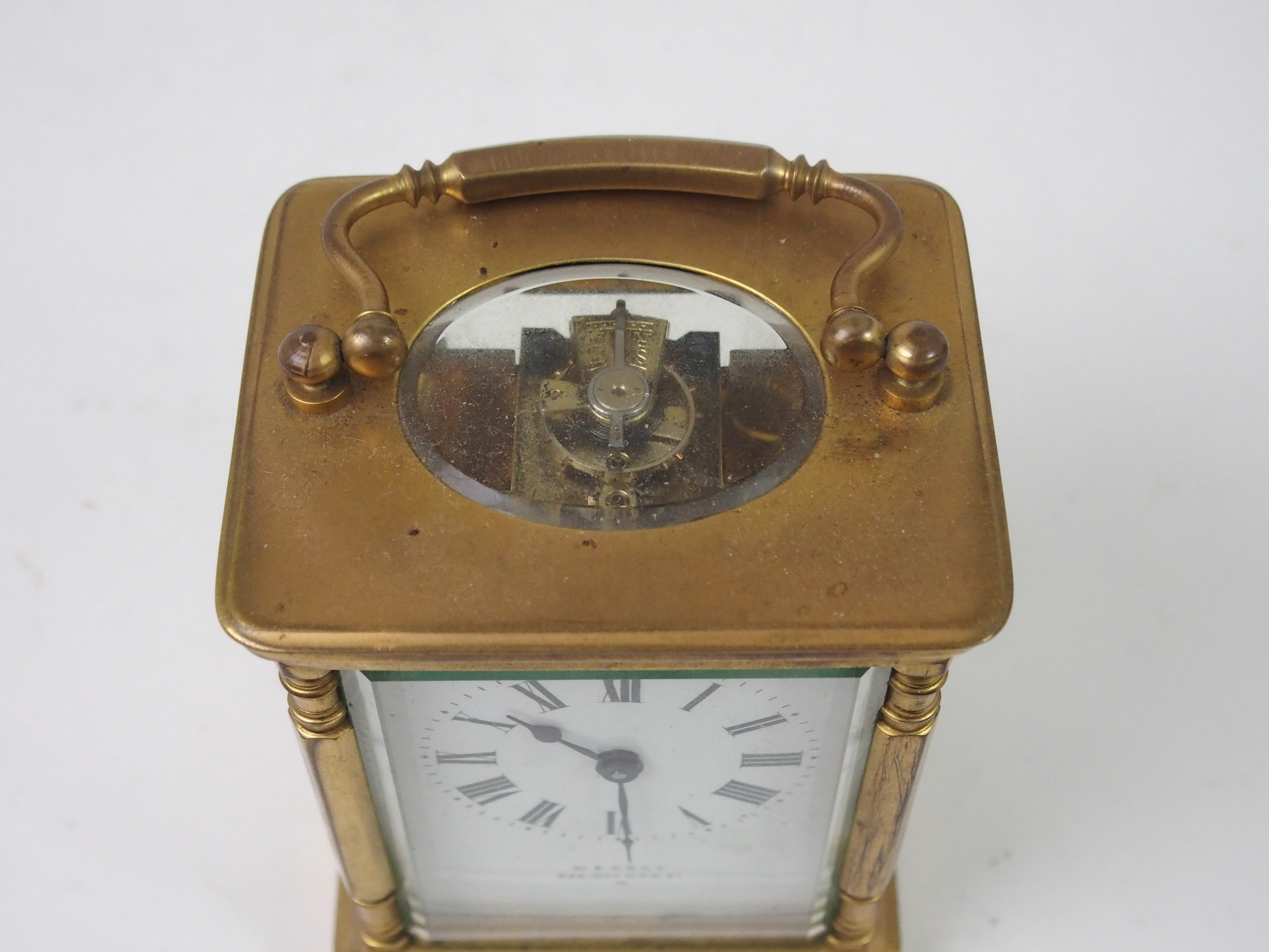 A FRENCH BRASS AND GLASS CARRIAGE CLOCK the white enamel dial with Roman Numerals, retailed by W. - Image 8 of 8