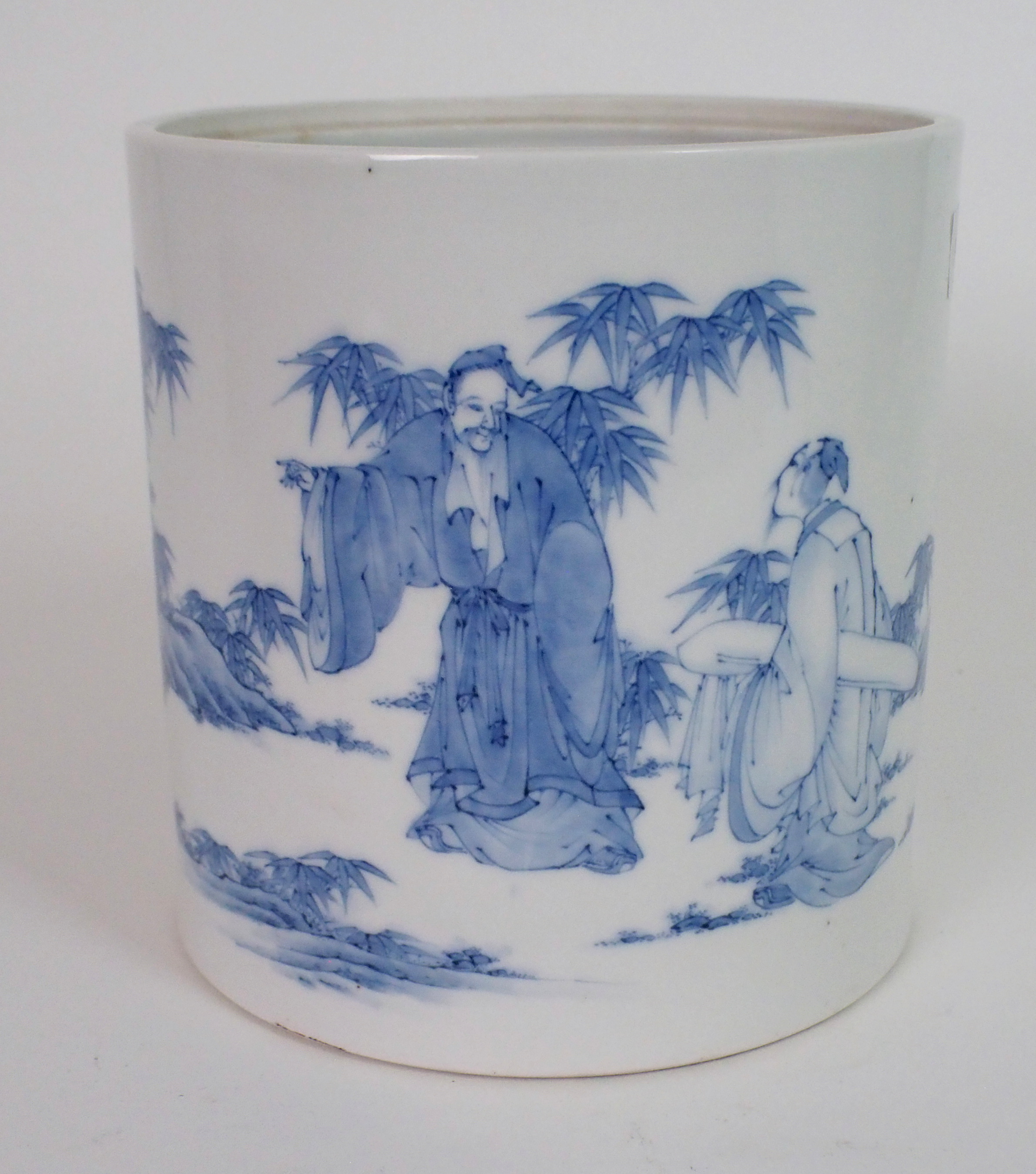 A CHINESE BLUE AND WHITE BROAD CYLINDRICAL JAR painted with scholars with scrolls in gardens, 16.5cm