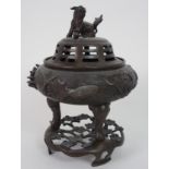 A CHINESE BRONZE INCENSE BURNER cast with kylin finial on a pierced cover and above fish and aquatic