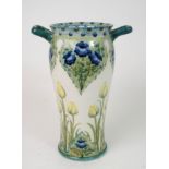 A WILLIAM MOORCROFT FOR JAMES MACINTYRE 'TULIPS AND ROSE' PATTERN VASE the two handled body with