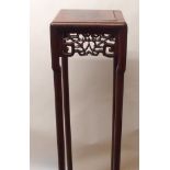 A CHINESE HARDWOOD VASE STAND the square top above foliate and key pattern frieze and on slender