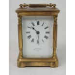 A FRENCH BRASS AND GLASS CARRIAGE CLOCK the white enamel dial with Roman Numerals, retailed by W.