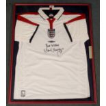 A WHITE ENGLAND SHORT-SLEEVED SHIRT the front autographed by Alan Thompson, 2004, framed and glazed,