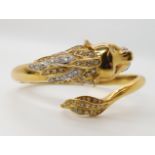 AN 18CT GOLD AND DIAMOND HINGED LION BANGLE set with estimated approx 0.70cts of eight cut diamonds,