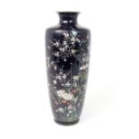 A JAPANESE CLOISONNE BALUSTER VASE decorated with birds on blossoming branches and over garden