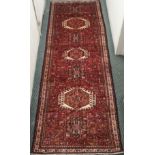 A red ground Karejeh runner with stylised animals and geometric designs, 315cm x 109cm Condition