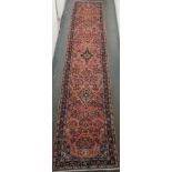A pink ground Sarough runner with three medallions and floral design, 407cm x 80cm Condition Report: