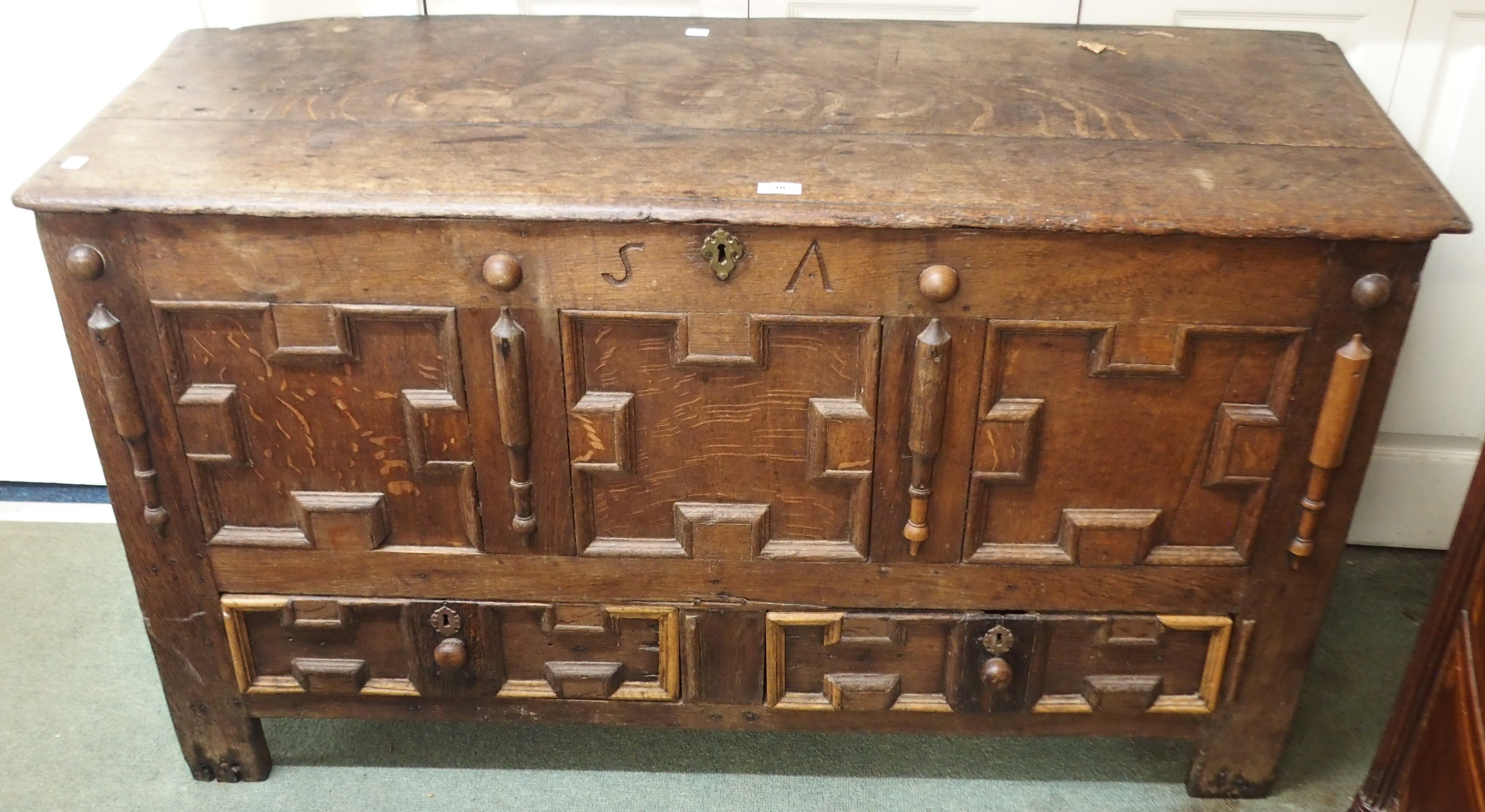 An oak coffer with panel front with two lower drawers and S A carved initials, 73cm high x 132cm