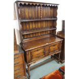 An oak dresser with open shelves on a base with two doors on stand, 194cm high x 122cm wide x 46cm