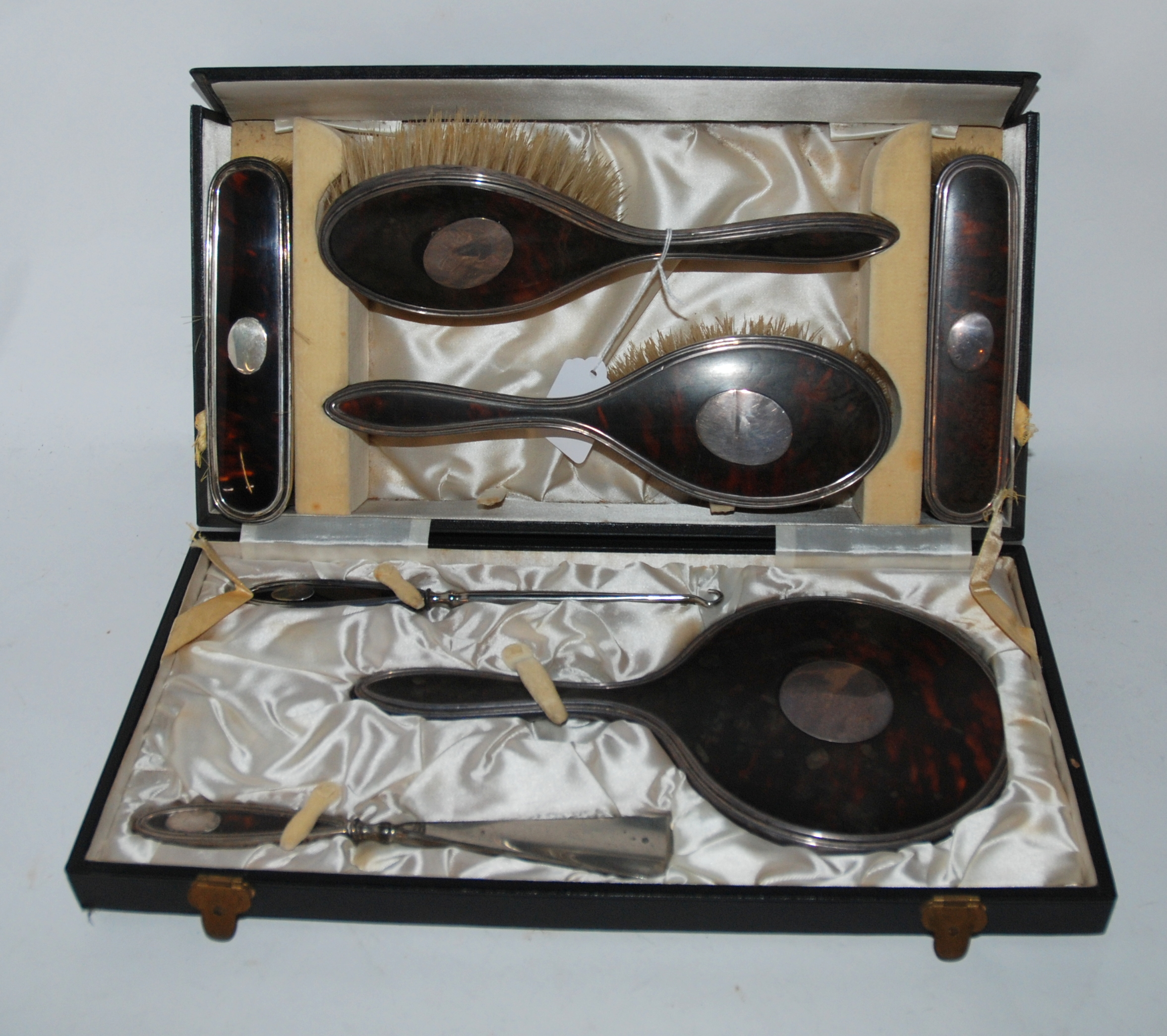 A cased seven piece silver and tortoiseshell dressing table set, Birmingham 1923 Condition Report: