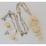 A Polynesian style carved bone pendant and earrings Condition Report: Not available for this lot