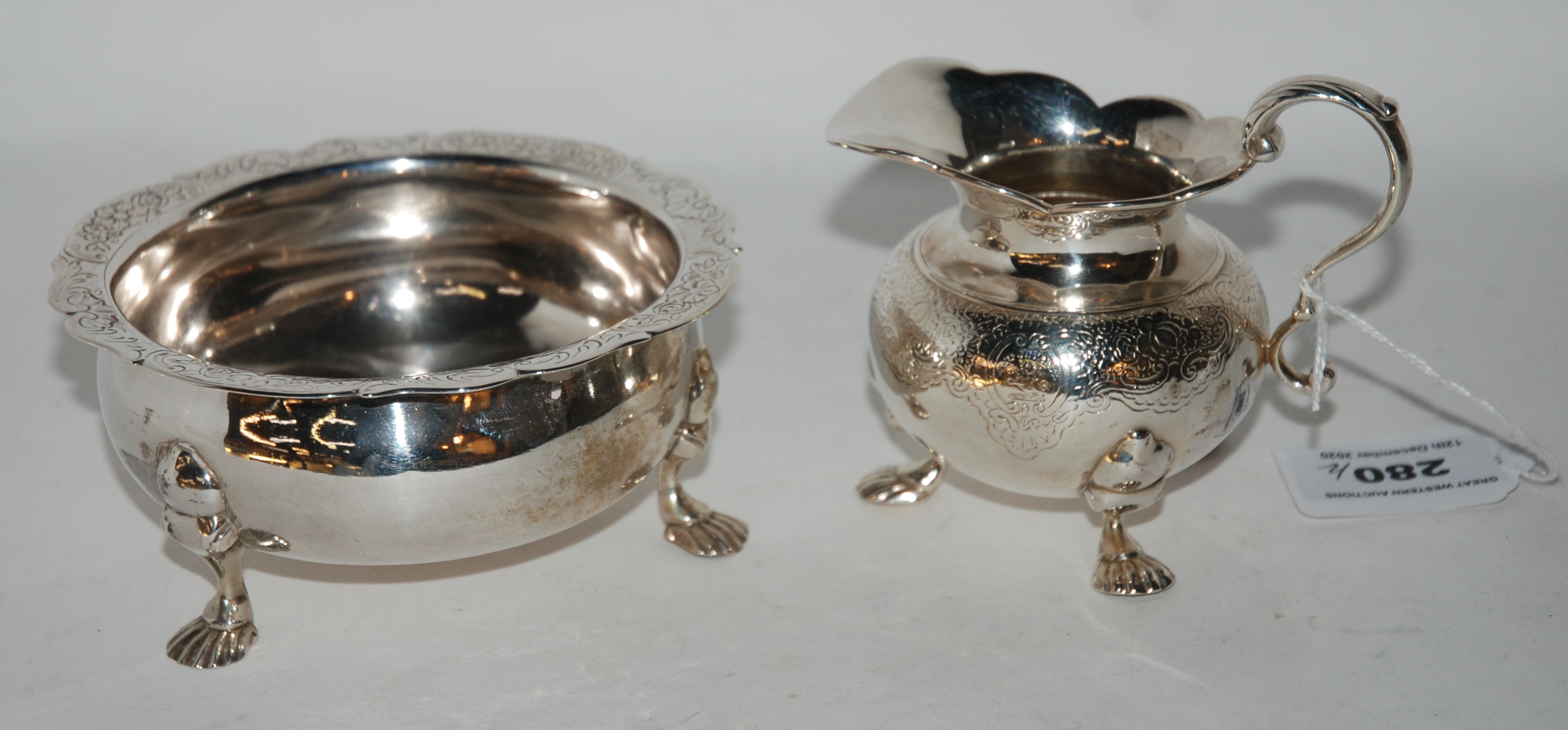 A white metal cream and sugar with engraved decoration (2) Condition Report: Available upon request