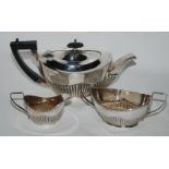 A bachelor's three piece silver tea service, Birmingham 1927, oval with half ribbed body, 329gms