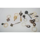 A lot comprising fourteen assorted white metal baby rattles, a plastic one and three baby whistles