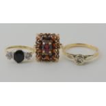A 9ct gold sapphire and cz three stone ring, size H1/2, a 9ct garnet cluster ring size K1/2, and a