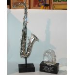 A saxophone ornament on stand, 67cm high and a Dizzy Gillespie American Eagle award, 1986 (2)