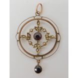 A yellow metal garnet and pearl set Edwardian pendant diameter 2.8cm, weight 2.7gms Condition