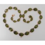 A Victorian style graduated gem necklace set with green pastes, mounted throughout in yellow