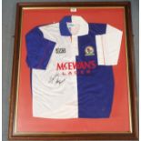 A blue and white Blackburn Rovers short-sleeved shirt, the front autographed by Alan Shearer, framed