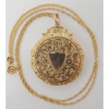 A yellow metal engraved locket diameter 3.3cm, with 9ct gold chain length 49cm, weight 10.2gms