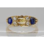 An 18ct gold blue gem and diamond ring, with scrolled setting (middle stone missing) size N,
