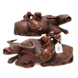 A pair of carved wood sculptures of water buffalo's and figures Condition Report: Available upon